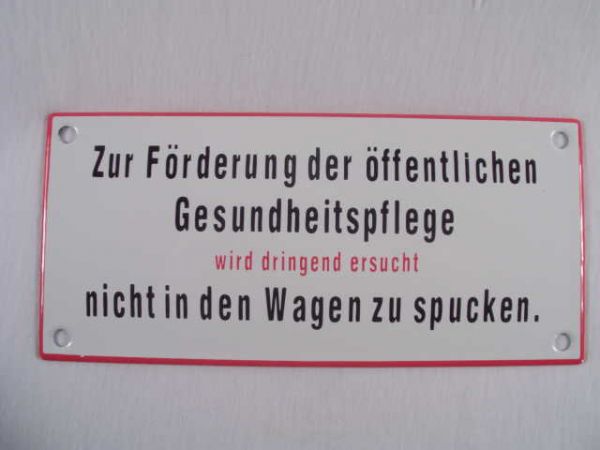 Emailleschild weiß, mit schwarzer Schrift  "Zur Förderung der öffentlichen Gesundheitspflege wird dringend ersucht nicht in den Wagen zu spucken " ca. 17 x 8  cm.